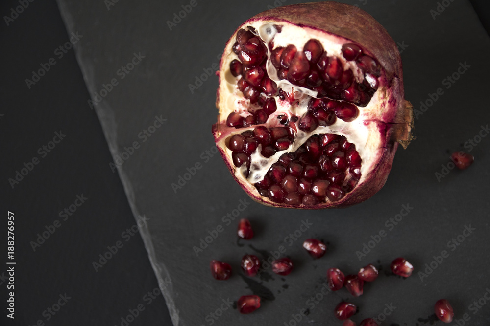 Ripe red pomegranate on a black background. Healthy food, diet concept Ripe red pomegranate on a black background. Healthy food, diet concept