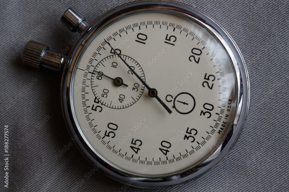 Stopwatch, on white denim background, value measure time, old clock arrow minute and second accuracy timer record Stopwatch, on white denim background, value measure time, old clock arrow minute and second accuracy timer record