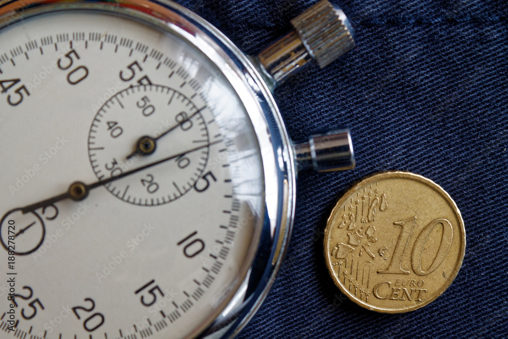 Euro coin with a denomination of 10 euro cents and stopwatch on obsolete blue denim backdrop - business background Euro coin with a denomination of 10 euro cents and stopwatch on obsolete blue denim backdrop - business background