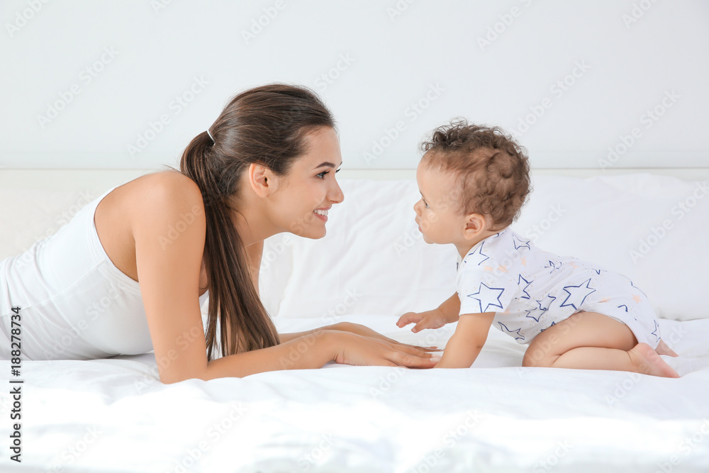 Mother and cute baby after bathing lying on bed at home Mother and cute baby after bathing lying on bed at home