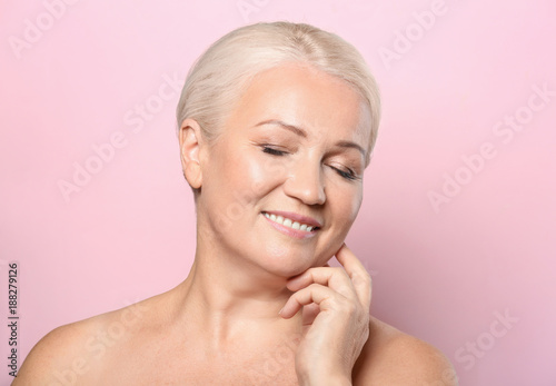 Portrait of beautiful mature woman on color background. Skin care concept