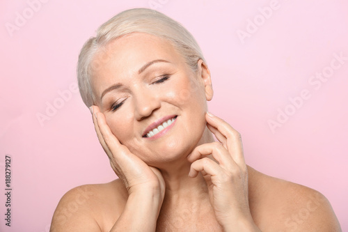 Portrait of beautiful mature woman on color background. Skin care concept