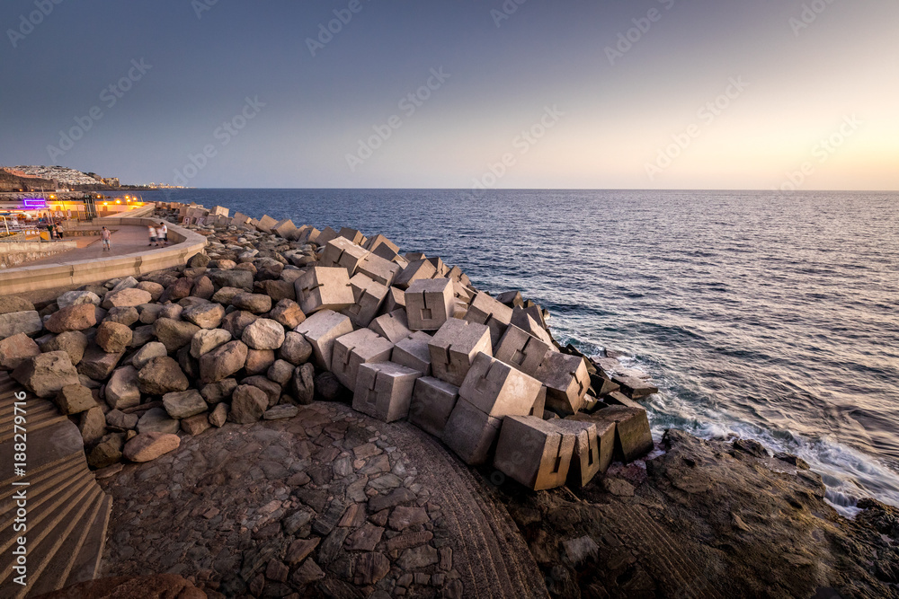 Breakwater blocks in the port of Puerto Rico, Gran Canaria, with the Atlantic Ocean in the background