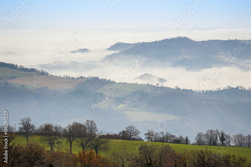 Silhouette di colline durante una giornata di nebbia photo