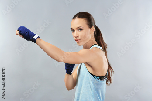 Strong boxer woman on grey background © Africa Studio