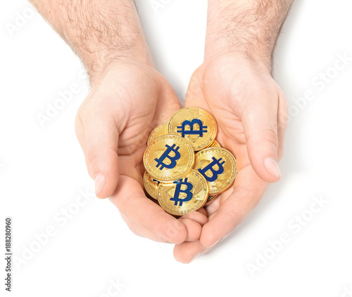 Male hands with golden bitcoins on white background
