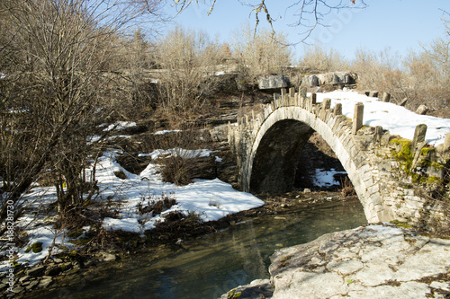 Arkoudas bridge old in Ioannina Zagori Greeece snow ice winter time © sea and sun