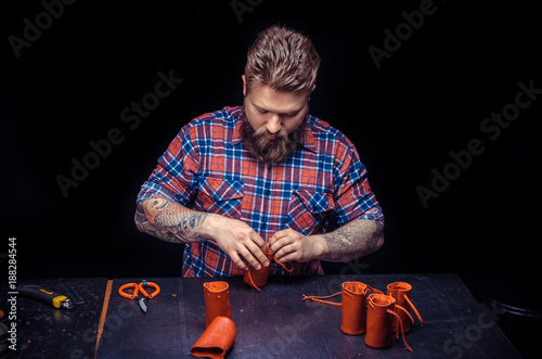 Skinner producing leather goods at the workshop photo