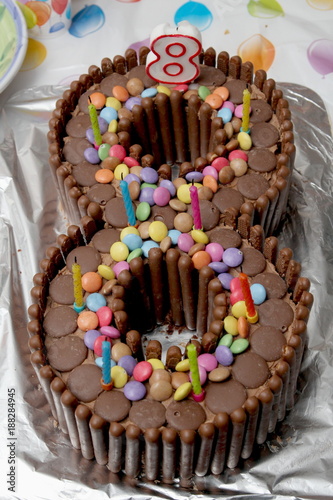 Birthday cake in the shape of a number eight, made from chocolate buttons, smarties and chocolate finger biscuits