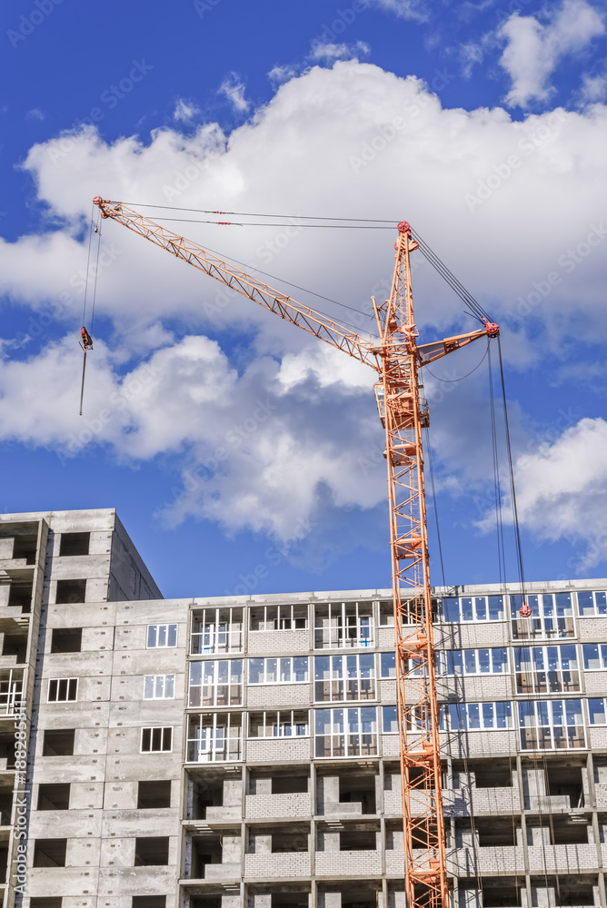 Crane and building construction site against blue sky