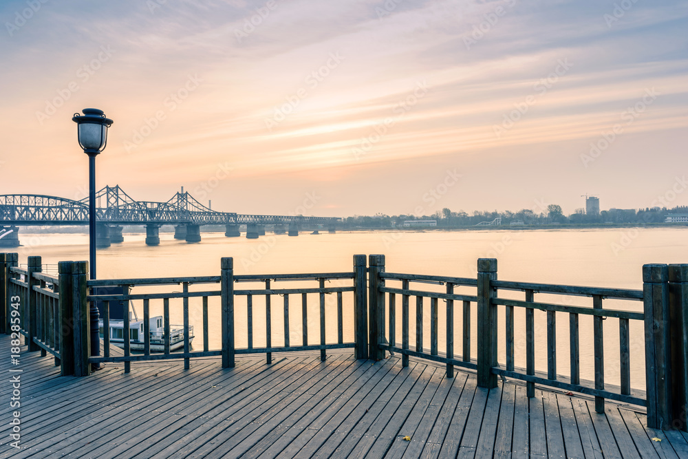 Yalu River Scenic Areas at morning. In the distance is Yalu River Bridge and North Korea. Located in Dandong, Liaoning, China.