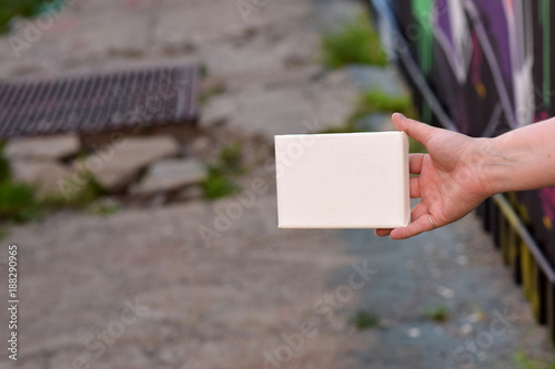Female hand with tiny canvas in front of urban background © Paul