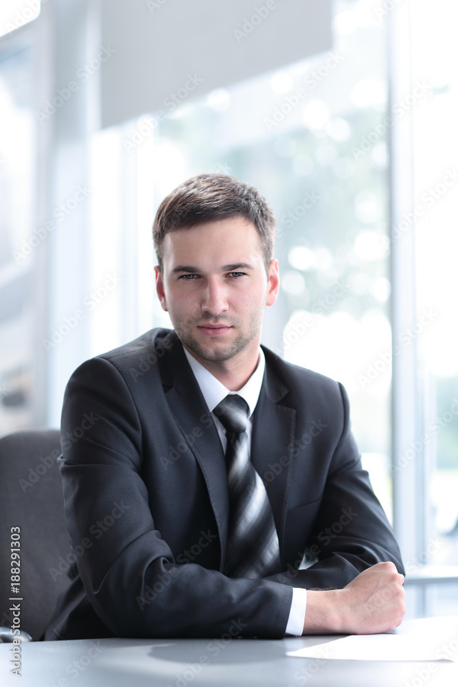 portrait of confident businessman sitting behind a Desk portrait of confident businessman sitting behind a Desk