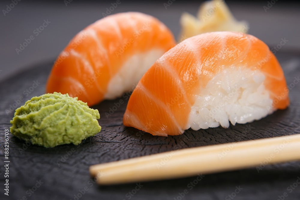 Delicious Japanese cuisine, nigiri sushi with salmon served with wasabi and ginger, close up. Sushi restaurant concept Delicious Japanese cuisine, nigiri sushi with salmon served with wasabi and ginger, close up. Sushi restaurant concept