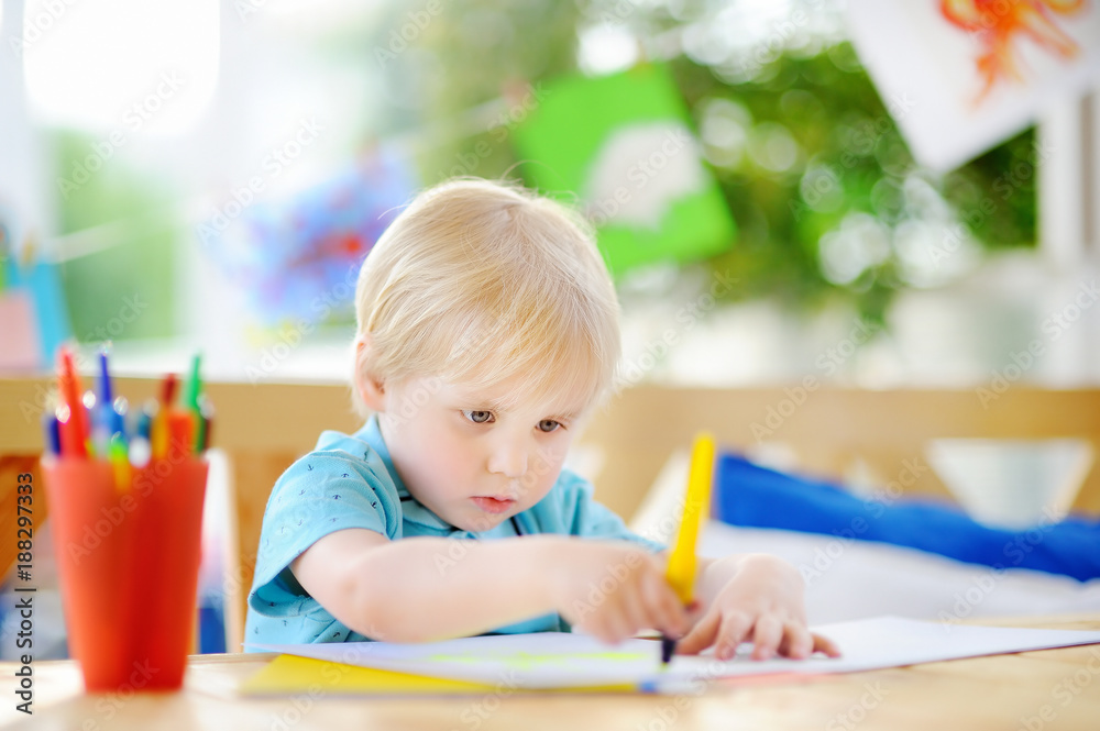 Cute little boy drawing and painting with colorful markers pens at kindergarten Cute little boy drawing and painting with colorful markers pens at kindergarten