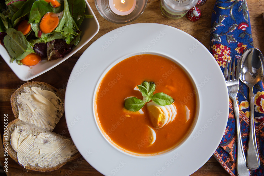 Tomato Bisque with Boiled Egg and Basil Garnish. High angle View Tomato Bisque with Boiled Egg and Basil Garnish. High angle View