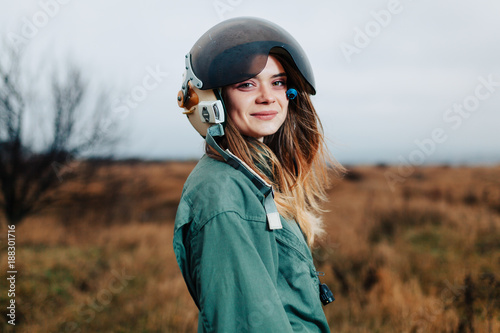 beautiful woman pilot of plane standing in the sunset field © Andrii