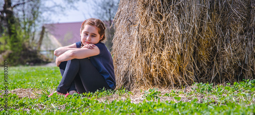 Girl, child with pigtails near a haystack photo