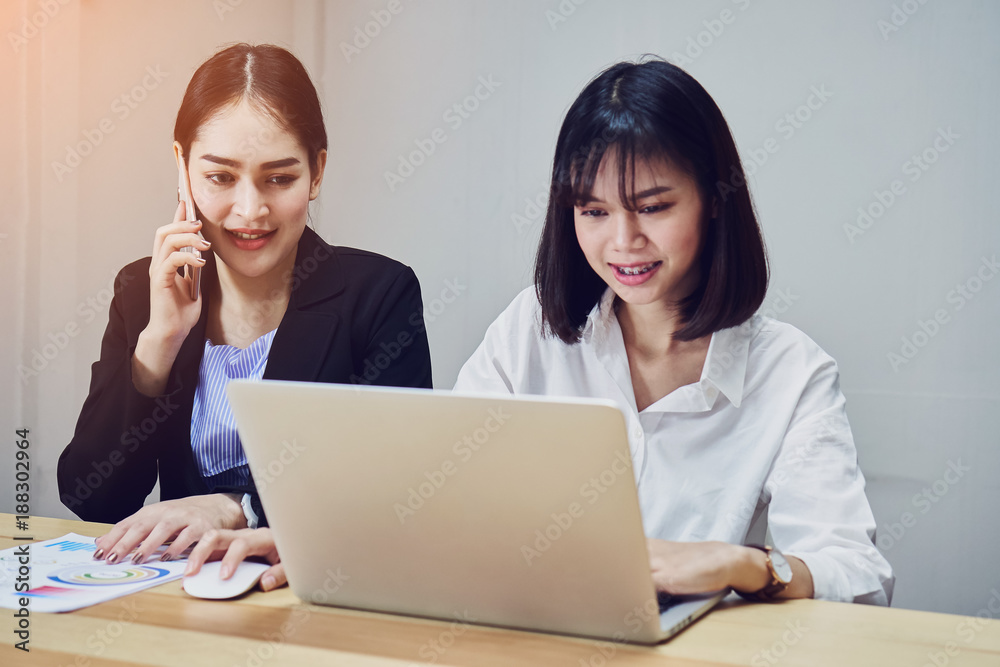 Business women are using laptops and smartphones to work in the office. Customer service outsourcing. Business women are using laptops and smartphones to work in the office. Customer service outsourcing.