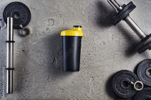 Fitness or bodybuilding concept background. Product photograph of old iron dumbbells on grey, conrete floor in the gym. Photograph taken from above, top view with lots of copy space photo