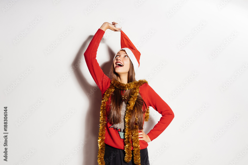 happy young girl takes off a red cap like Santa Claus from his head, waiting for a new year and Christmas