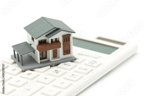 A model house model is placed on a calculator. as background property real estate concept with copy space for your text or design.