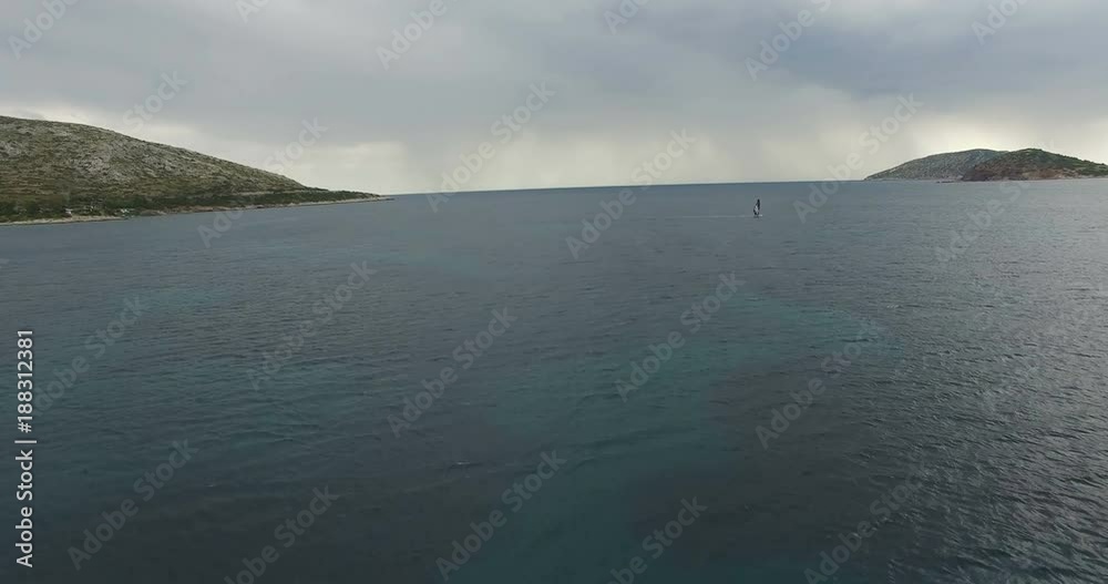 Aerial view of a windsurfer on the calm sea surface Aerial view of a windsurfer on the calm sea surface