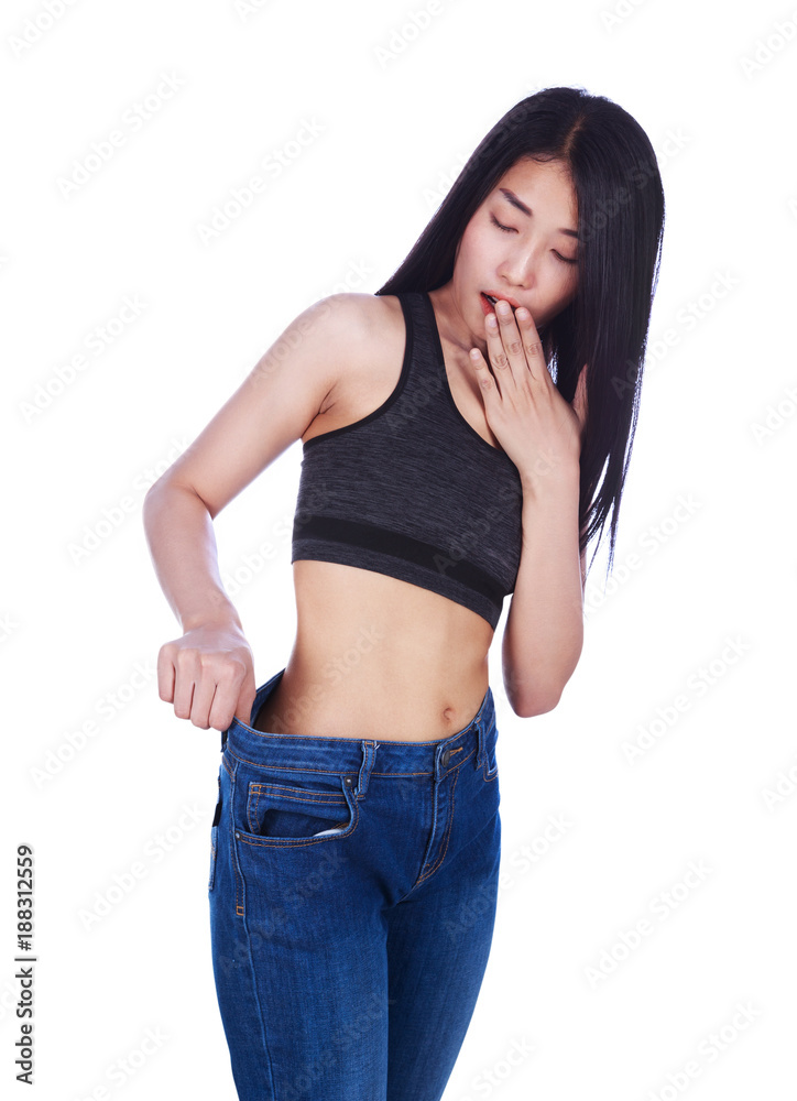 Shocked slim fitness woman in old jeans after losing weight isolated on white background Shocked slim fitness woman in old jeans after losing weight isolated on white background