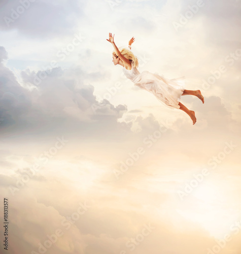 Woman in a white dress flying in the sky. Serenity