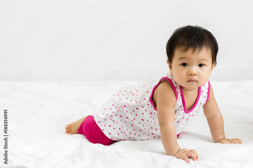 Portrait of adorable baby girl crawling on the bed, indoors Portrait of adorable baby girl crawling on the bed, indoors