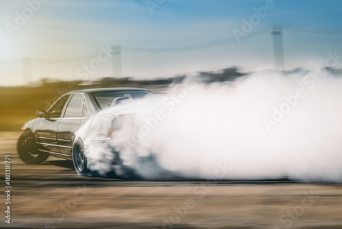 Drift driving is approaching the high speed curve and has a lot of smoke. This image is motion blur.