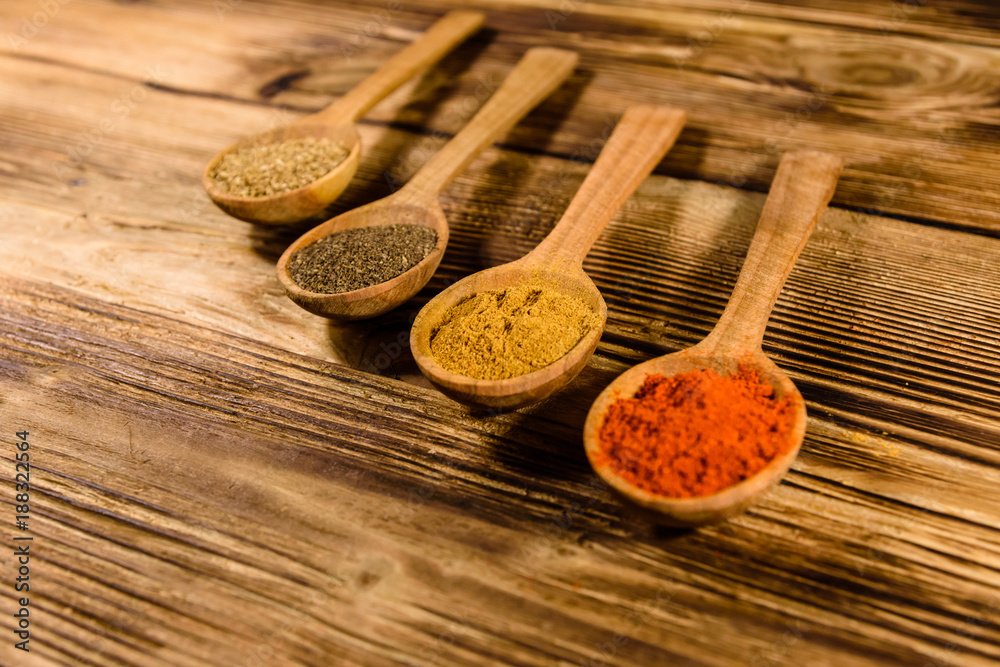Spoons with the different spices on wooden table Spoons with the different spices on wooden table