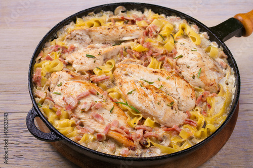 One pan chicken, bacon and mushrooms with egg noodles in frying pan, horizontal