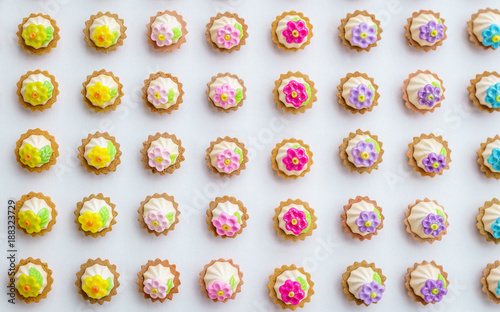 A lot of artificial cupcakes on white surface with shallow depth of field background.