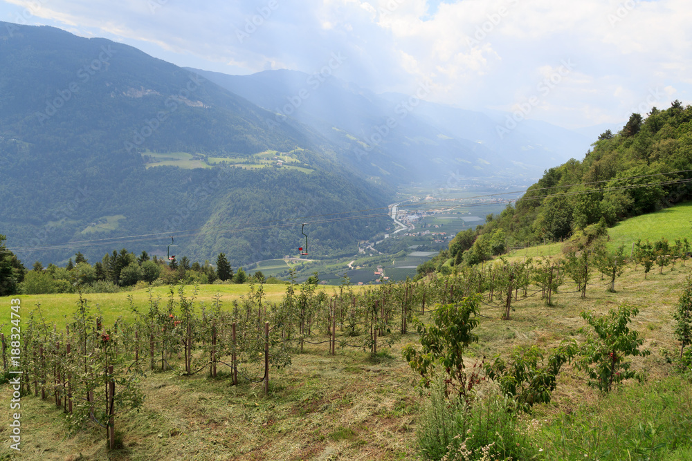 Chairlift, apple trees and mountain panorama in Algundo, South Tyrol