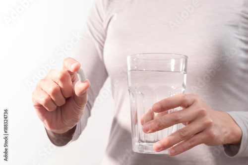 isolate of the women hand holding the medicine with a glass of water, medicine recovery concept