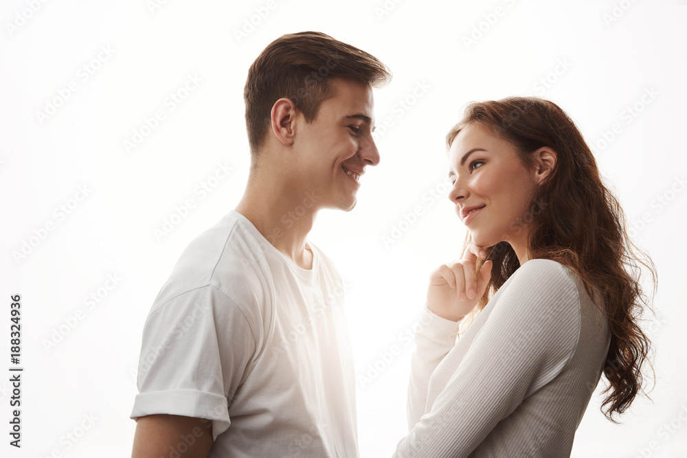 Sideways portrait of two adults in love. Guy flirts with beautiful girl trying to ask her for a date. He makes her smile. Every woman loves handsome boys with sense of humour Sideways portrait of two adults in love. Guy flirts with beautiful girl trying to ask her for a date. He makes her smile. Every woman loves handsome boys with sense of humour