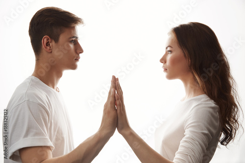 Couple in love looking at each other in white room. Man and woman holding hands showing that they are bonded together. She knows that boyfriend will always be there for her so as she.