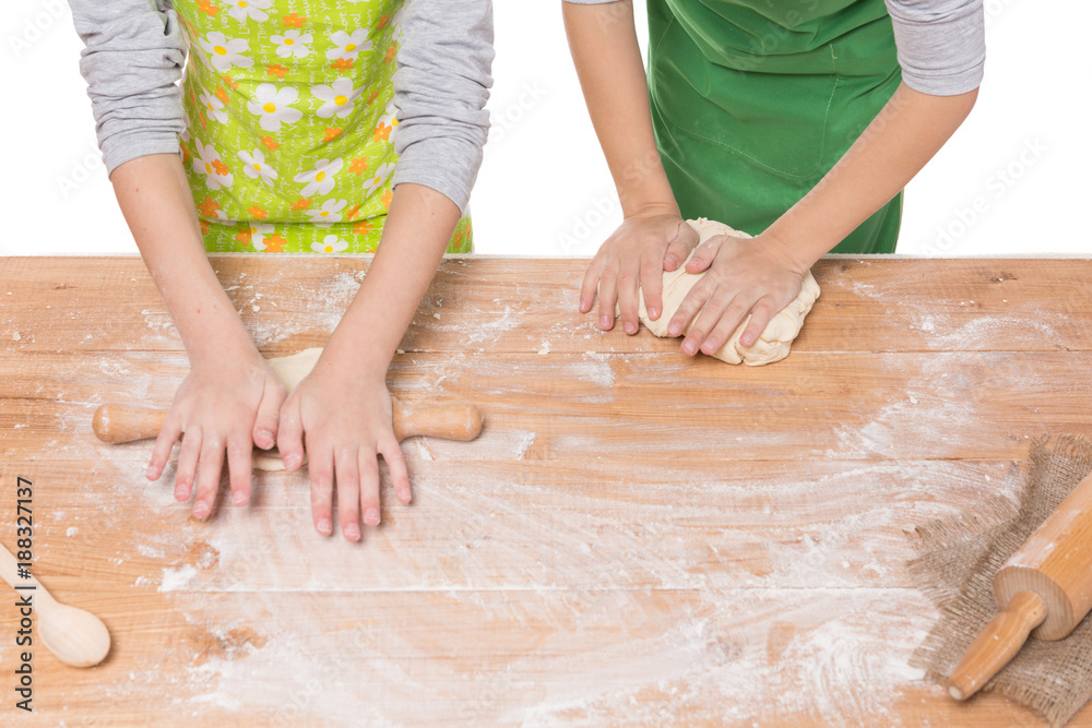 hands of children, boy and girl knead the dough on a wooden board