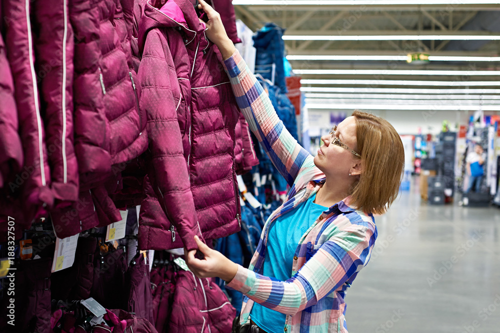 Woman chooses winter jacket in store