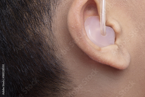 A male patient using mini behind the ear hearing aid.