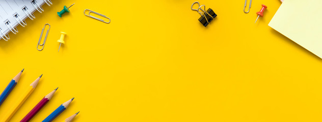 Colorful office and educational supplies on  yellow paper, panoramic banner background with copy space