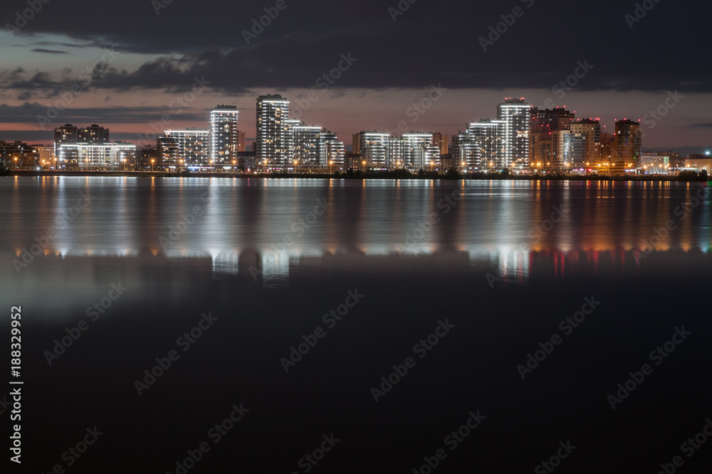 view of night city reflecting in the water