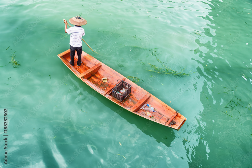 Fototapeta premium Amazing top view of Asian boatman in traditional bamboo hat