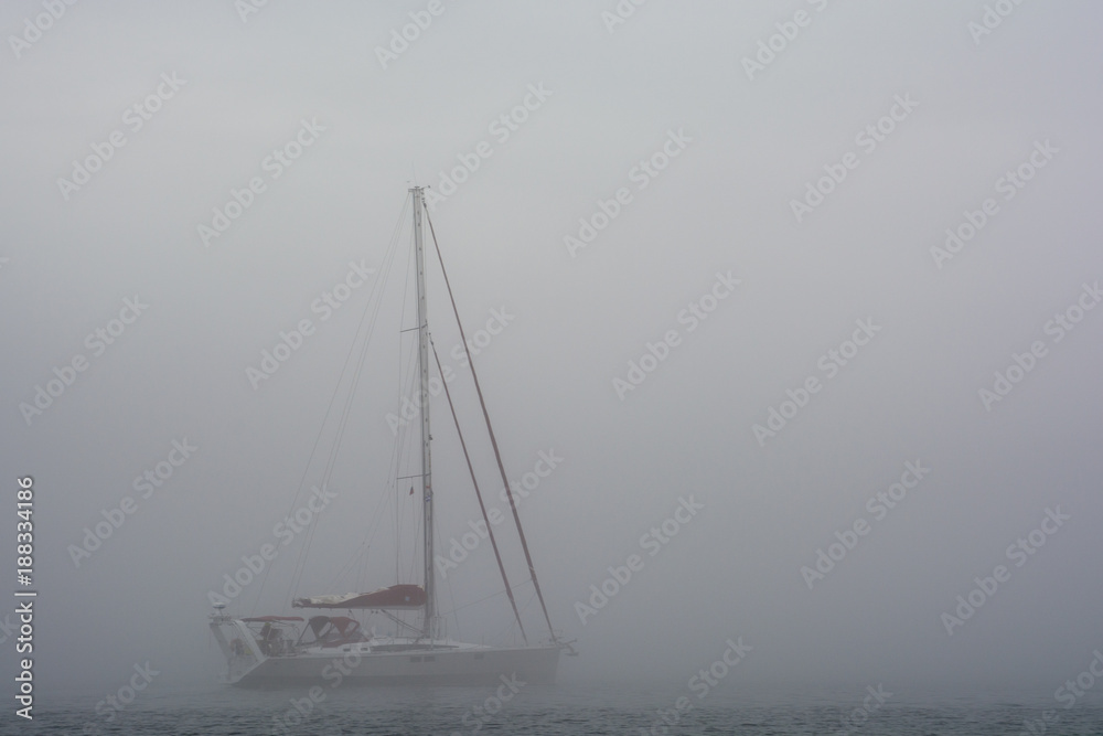 Yacht in the fog. Grey view to sailing.