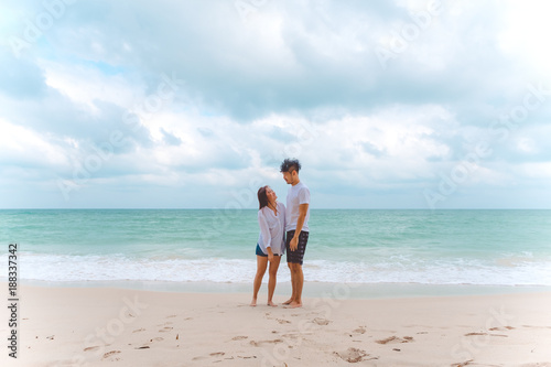 Portrait image of a lover couple looking at each other with feeling loved on the beach , the sea and blue sky background