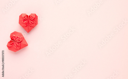 Red hearts origami paper on pink background, Valentine's day and love. Top view with space to copy.