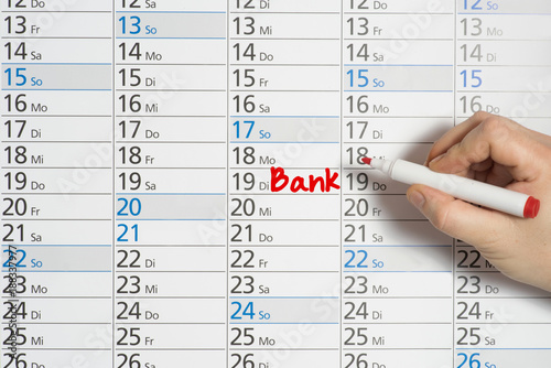 Ein vermerkt einen Termin bei der Bank in einem Kalender