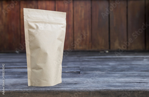 Brown paper bag with space on wood background, tea bag packaging 