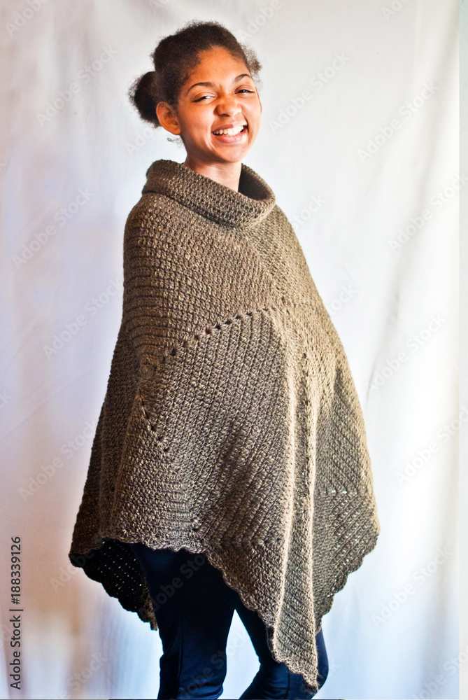 happy girl wrapped in warm handmade poncho Stock Photo | Adobe Stock